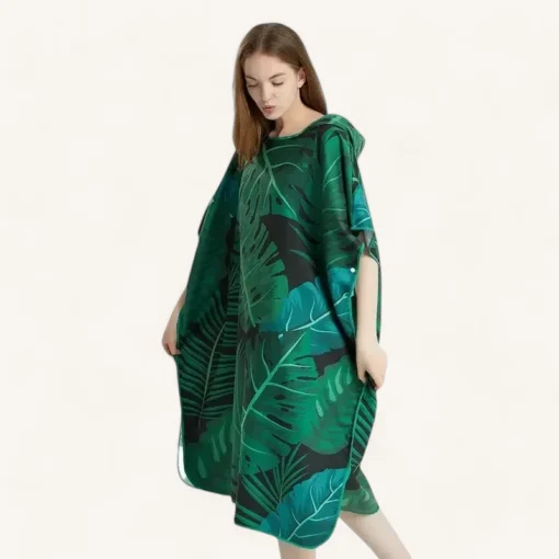 Jeune femme en poncho tropical vert, capuche. Élégance décontractée, idéal pour temps chauds.