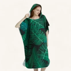 Femme en poncho tropical vert vif à capuche, parfait pour lété.