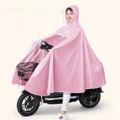 Femme joyeuse en poncho rose sur scooter électrique, parfaite pour les jours de pluie.