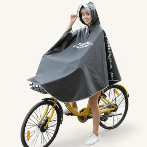 Jeune femme stylée sur un vélo jaune, portant un poncho noir élégant contre la pluie.