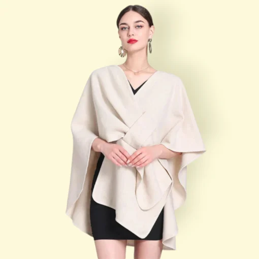 Modèle en cape chaude femme beige élégant sur robe noire, avec maquillage audacieux et accessoires raffinés.