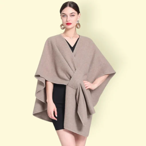 Modèle en cape chaude femme chic beige élégant sur robe noire, accessoire chic et maquillage soigné.