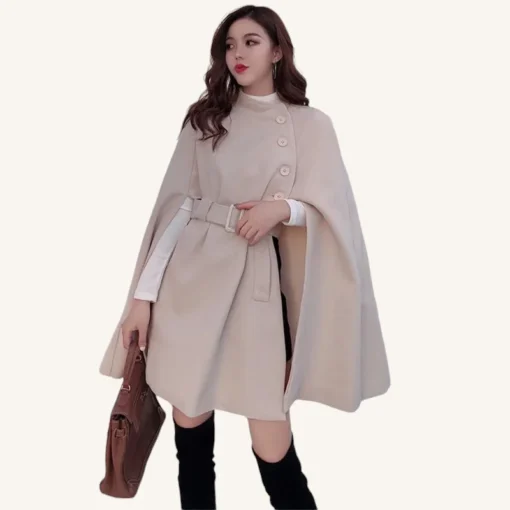 Manteau cape beige élégant, col roulé blanc et bottes noires pour un look automnal chic.