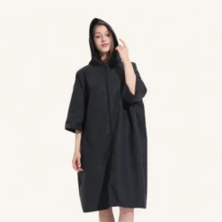 Femme élégante dans pull noir à capuche oversized.