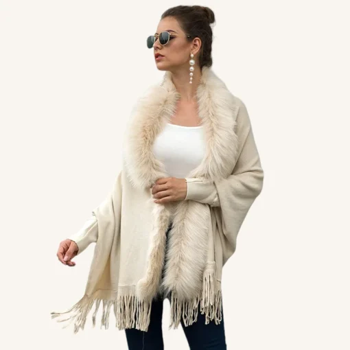 Femme élégante en shawl crème avec col en fausse fourrure, accessoires modernes et style raffiné.