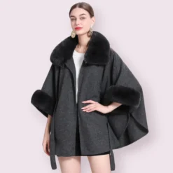 Modèle élégant en manteau cape femme gris avec col en fourrure, alliant modernité et sophistication.