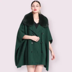 Modèle avec un élégant manteau en cape vert et col en fourrure.