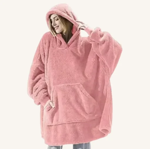 Femme en poncho rose oversized, mélange parfait de confort et de style décontracté.