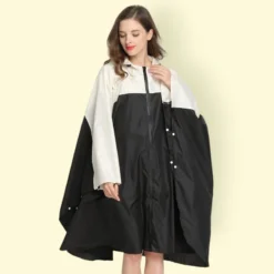 Femme élégante en poncho de pluie randonnée de pluie noir et blanc, alliant style et fonctionnalité.