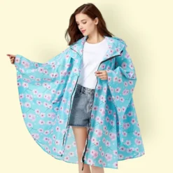 Femme stylée en Poncho Femme Pour la Pluie floral turquoise, parfaite pour l'été.