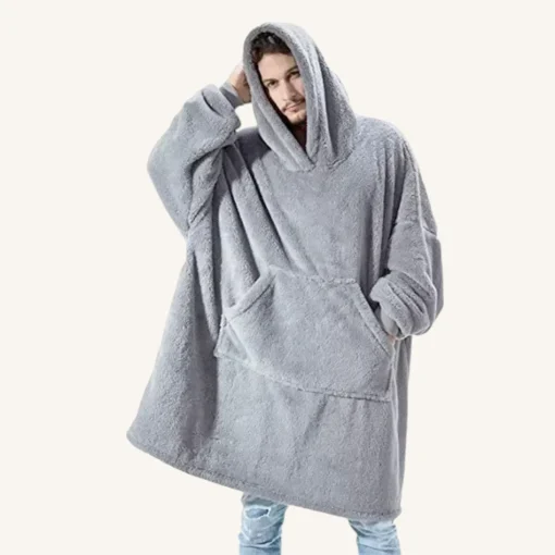 Personne détendue en poncho gris oversize, idéale pour le confort et le style décontracté.