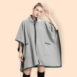 Femme élégante en poncho gris stylisé, chic et moderne, avec accessoires raffinés.