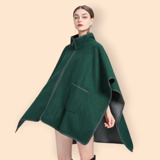 Modèle en poncho veste vert tendance avec des bottes noires élégantes sur fond beige.