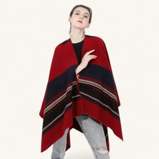 Poncho rouge et bleu avec motifs géométriques porté par une femme élégante.