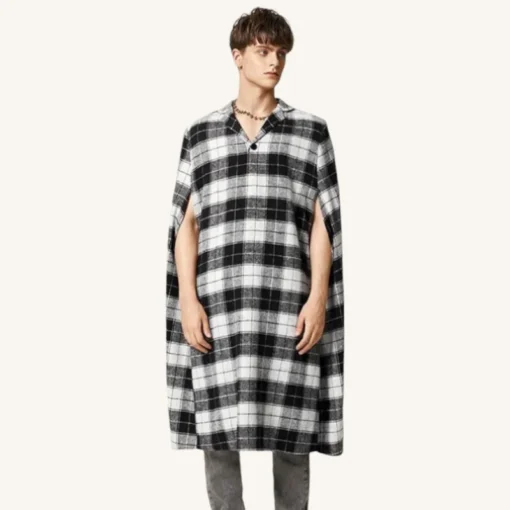 Cape en plaid noir et blanc portée par un jeune homme au style moderne.